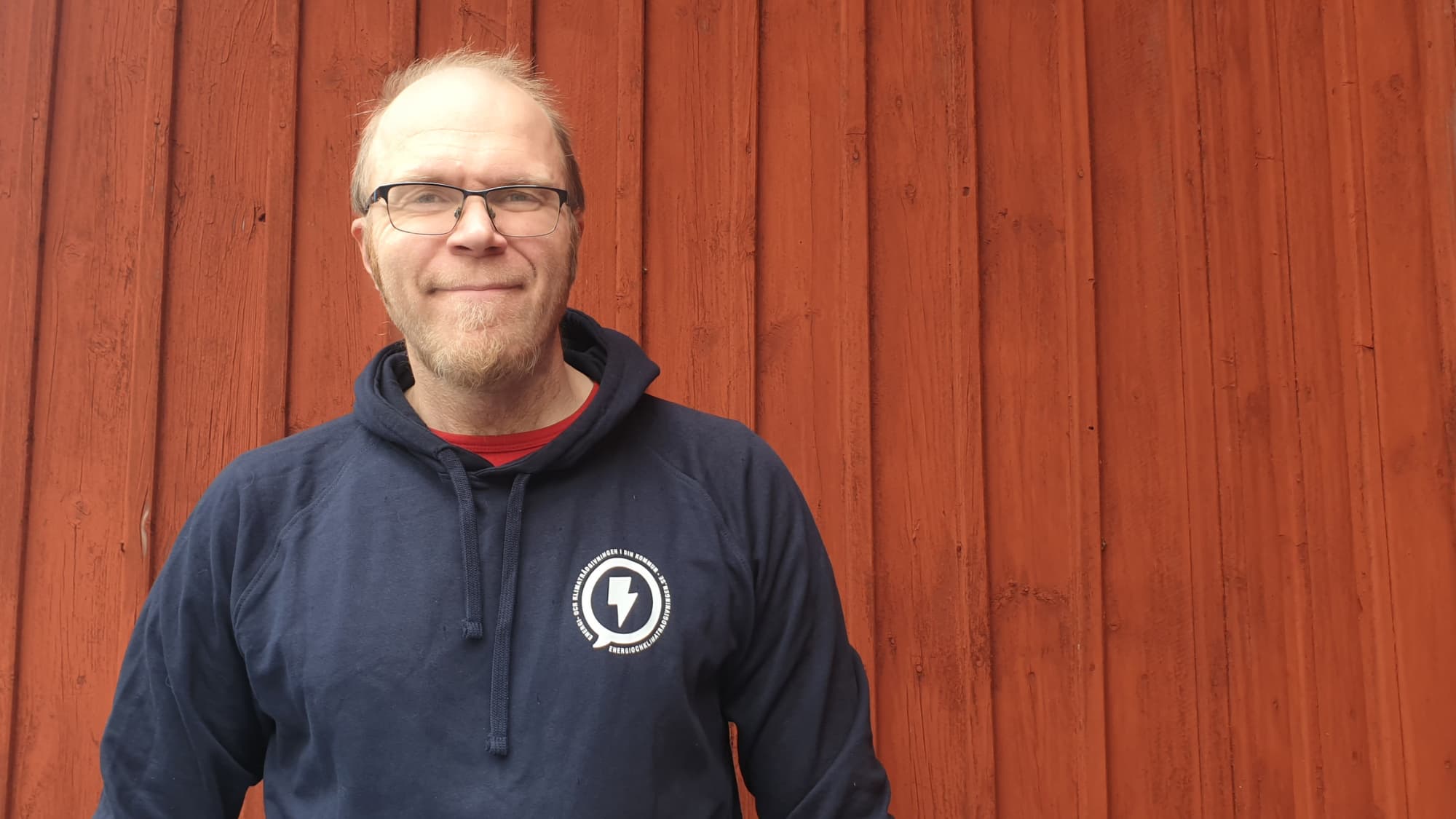 Anders Tång Energi- och klimatrådgivare, Söderhamns kommun står framför röd husvägg